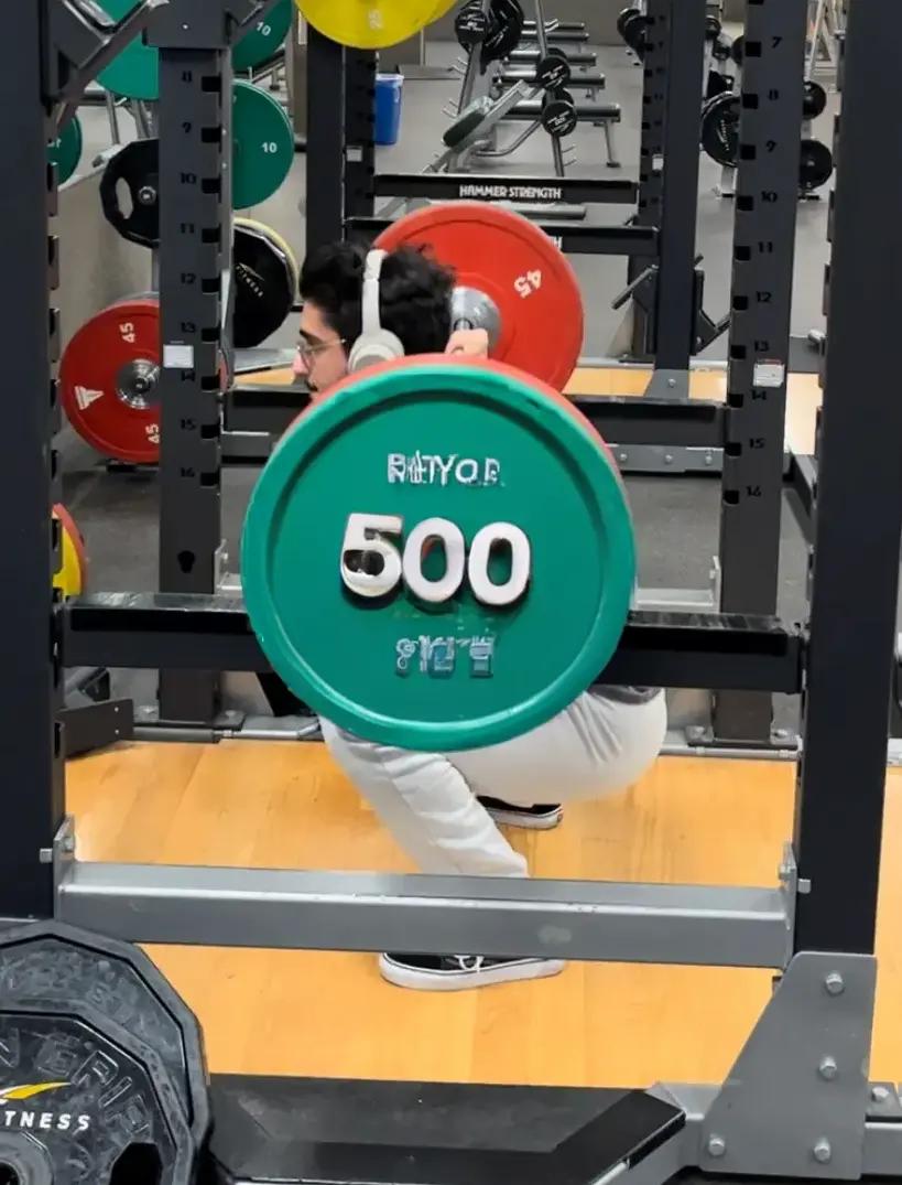 Mohammed squatting in the gym with fake weights making it look like it is very heavy